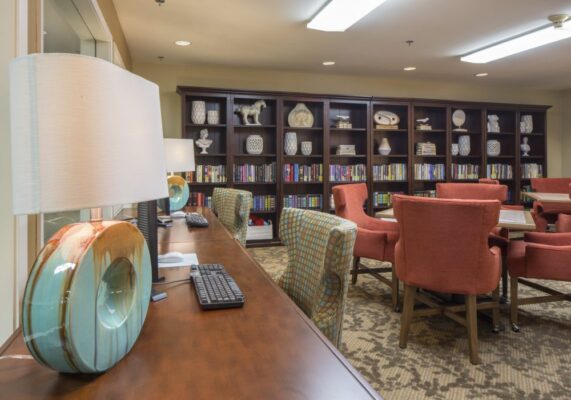 Reading Room library at Markham House with bookshelves and books, desks, chairs, tables, aand lamps